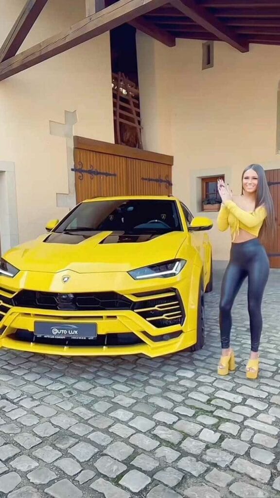 Tifany Wallemacq in heißen Leggins neben Sportwagen