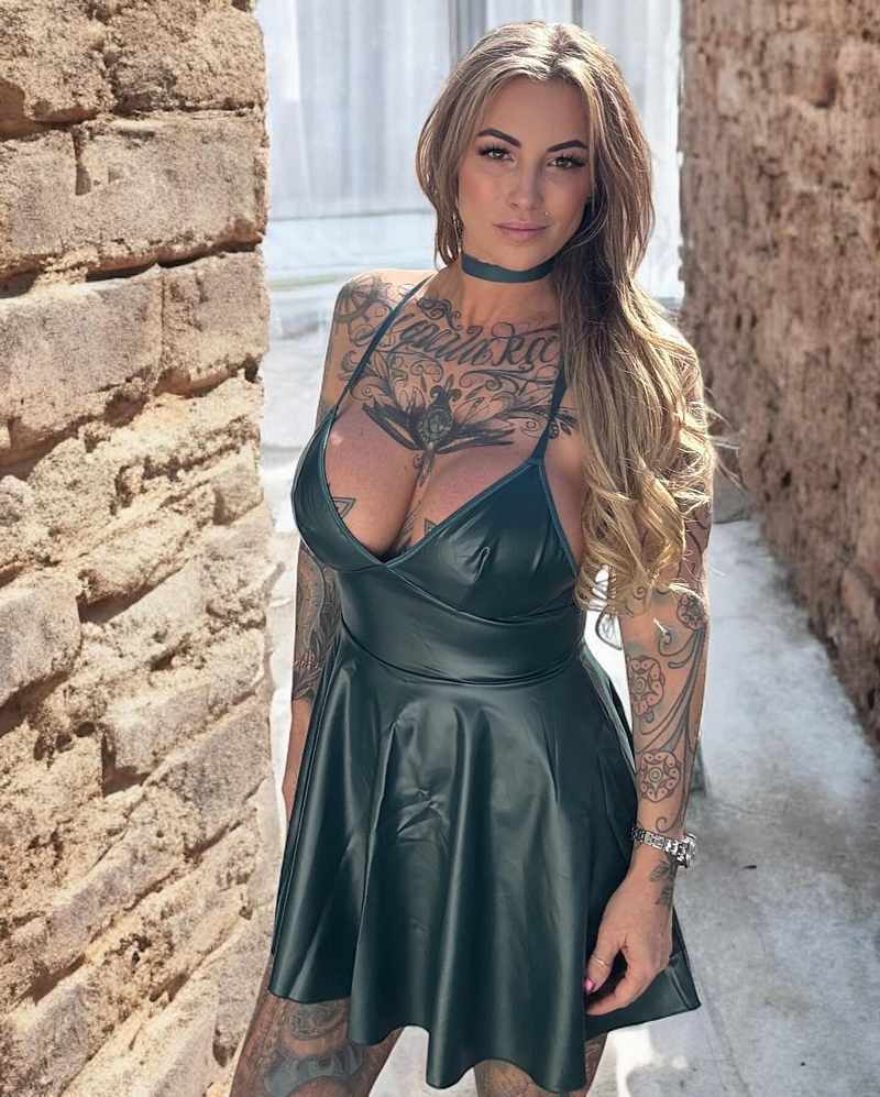 K Fox trägt ein grünes Lederkleid