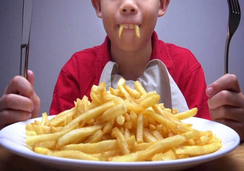 Teenager eating fries