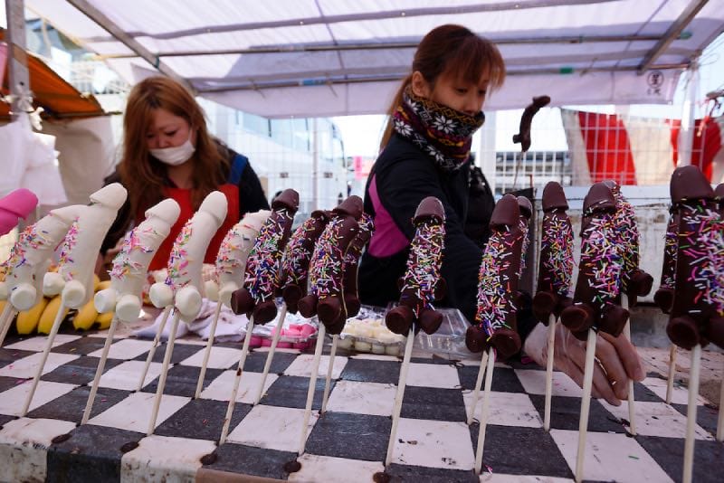 People selling steel phallus shaped candy