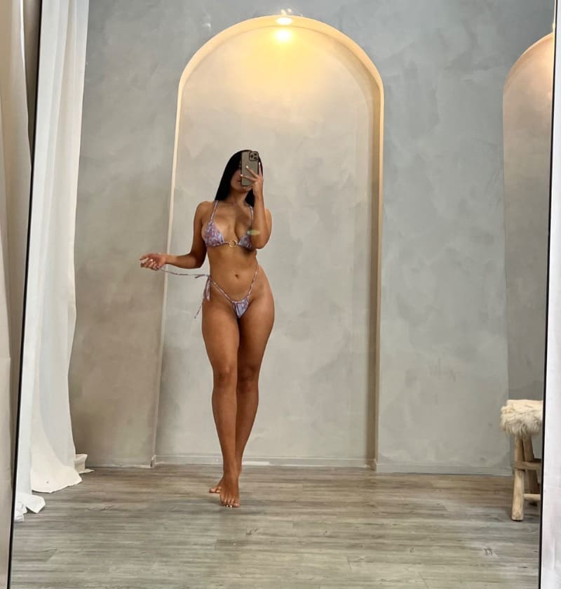 Babe in sexy bikini in front of mirror