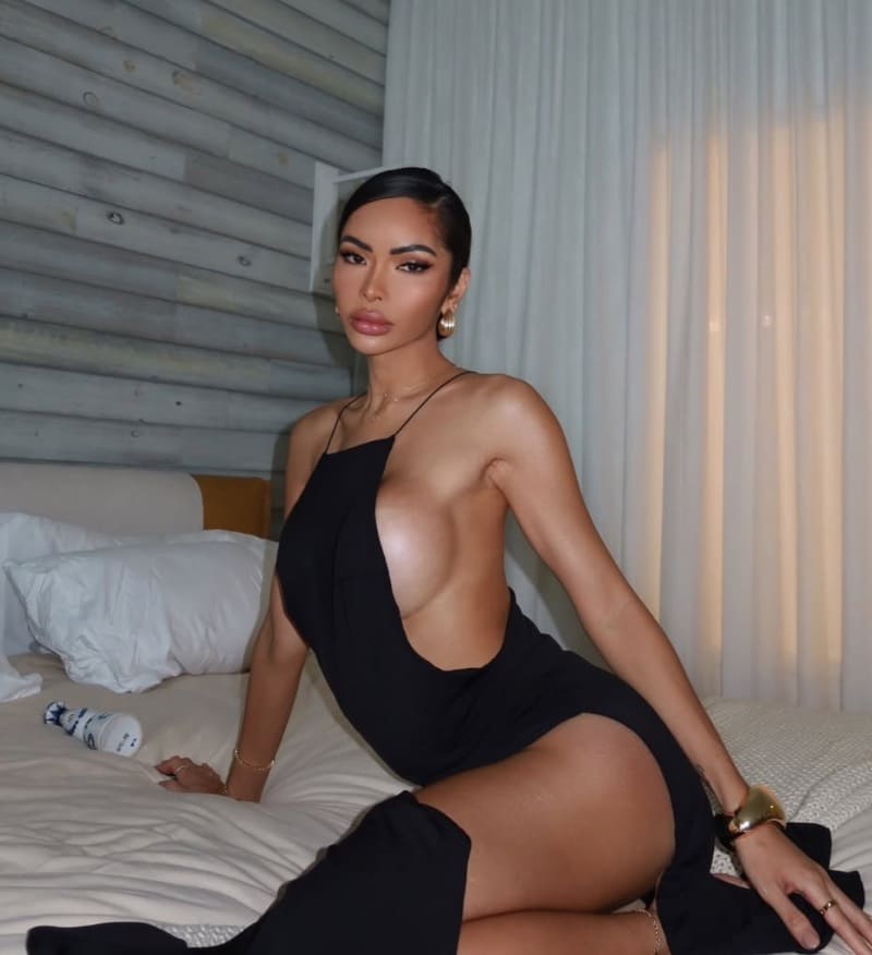 Babe flaunting figure on bed in tight dress
