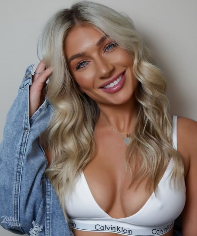 Blonde woman with big cleavage in white top and jeans jacket