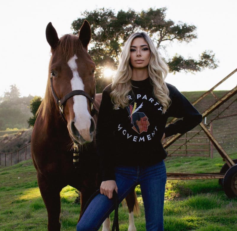 Hannah in sexy outfit next to horse