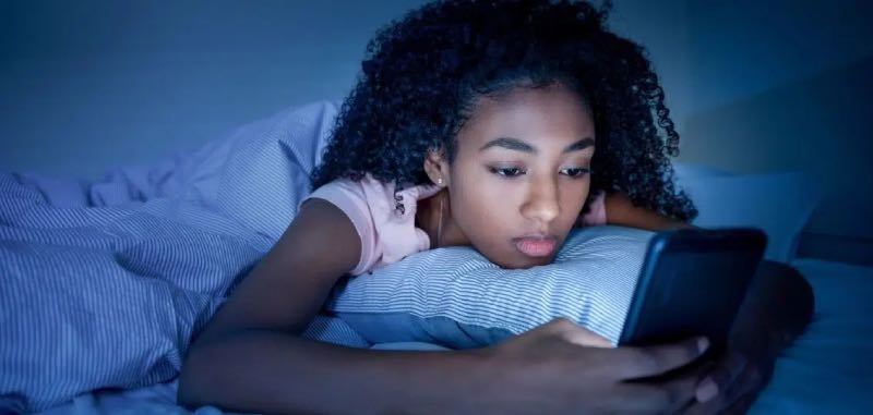 Teen on Phone looking at screen time 