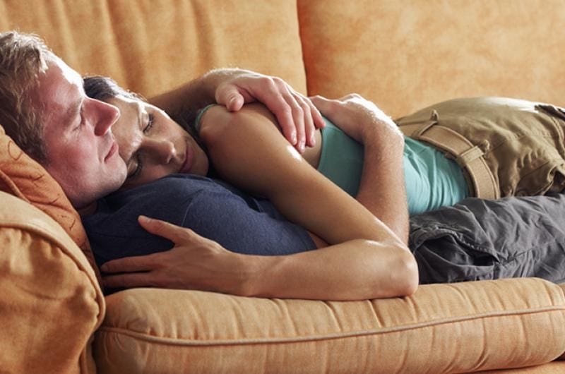 Mensen op zetel met lichamelijke genegenheid 