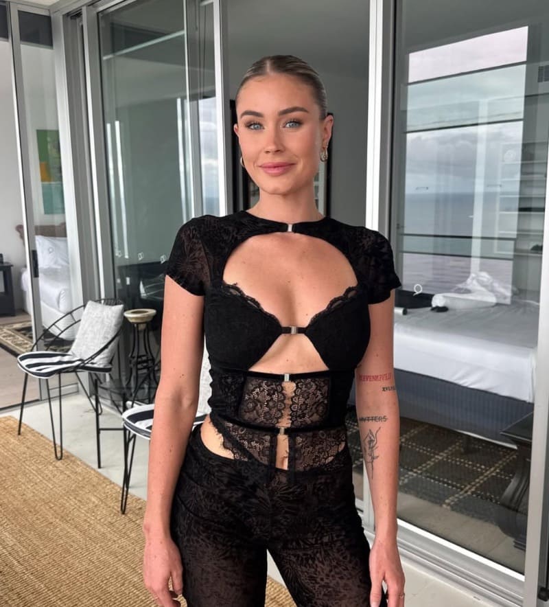 Sexy blondine in zwarte outfit met diepe decolleté