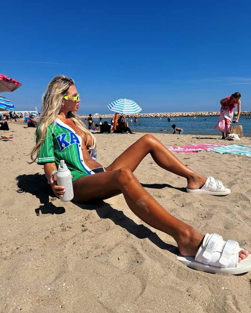 Christine McGuinness entspannt breitbeinig am Strand