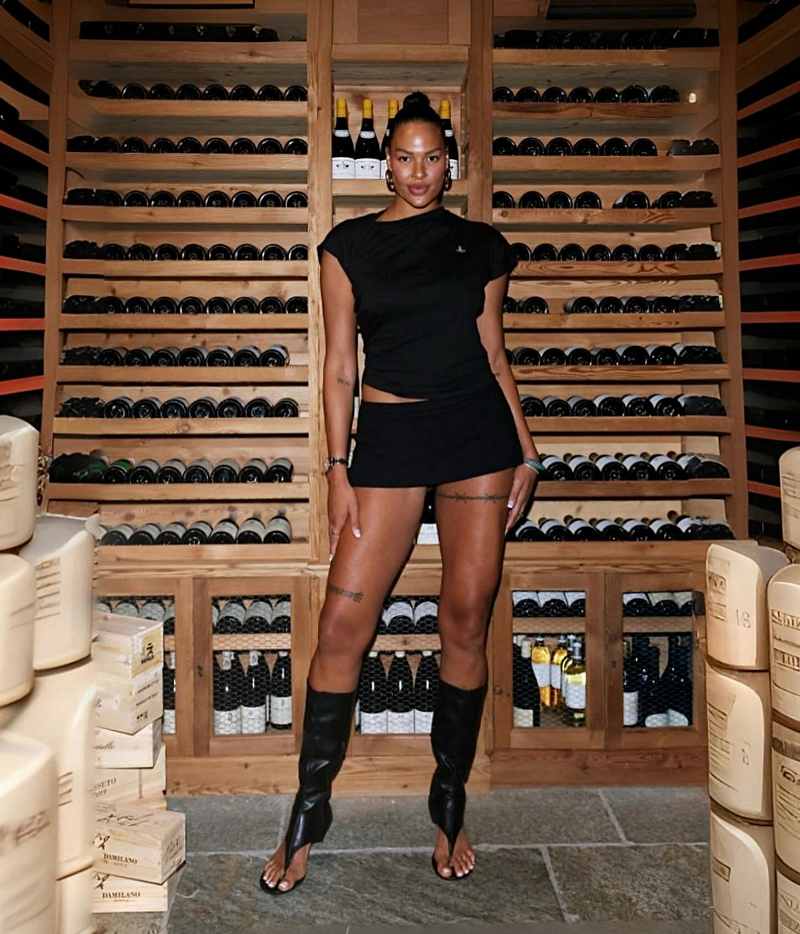 Elizabeth Cambage sexy Frau vorm gefüllten Weinregal