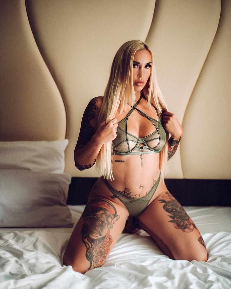 Kara Kay kniet im Bett und hat sexy Unterwäsche an