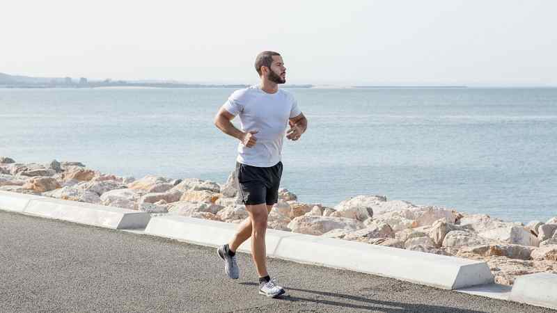 Mann joggt am Ufer