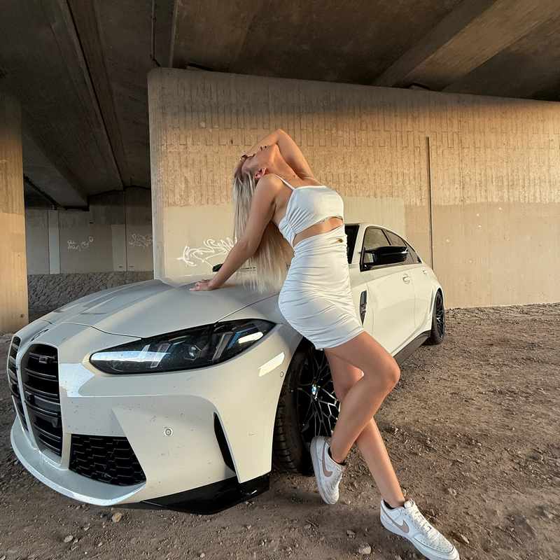 Julia Catalina posiert an ihrem BMW M3