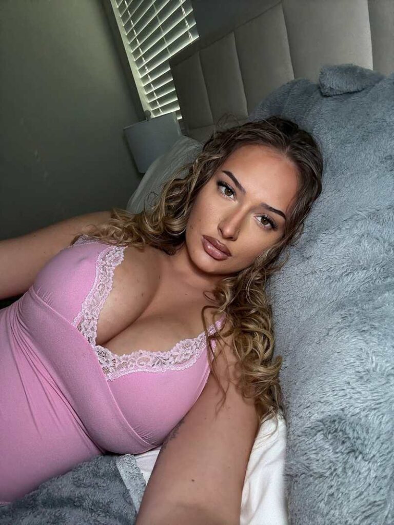 Ariana Nicole liegt im Bett und drückt ihre Brüste in die Kameralinse