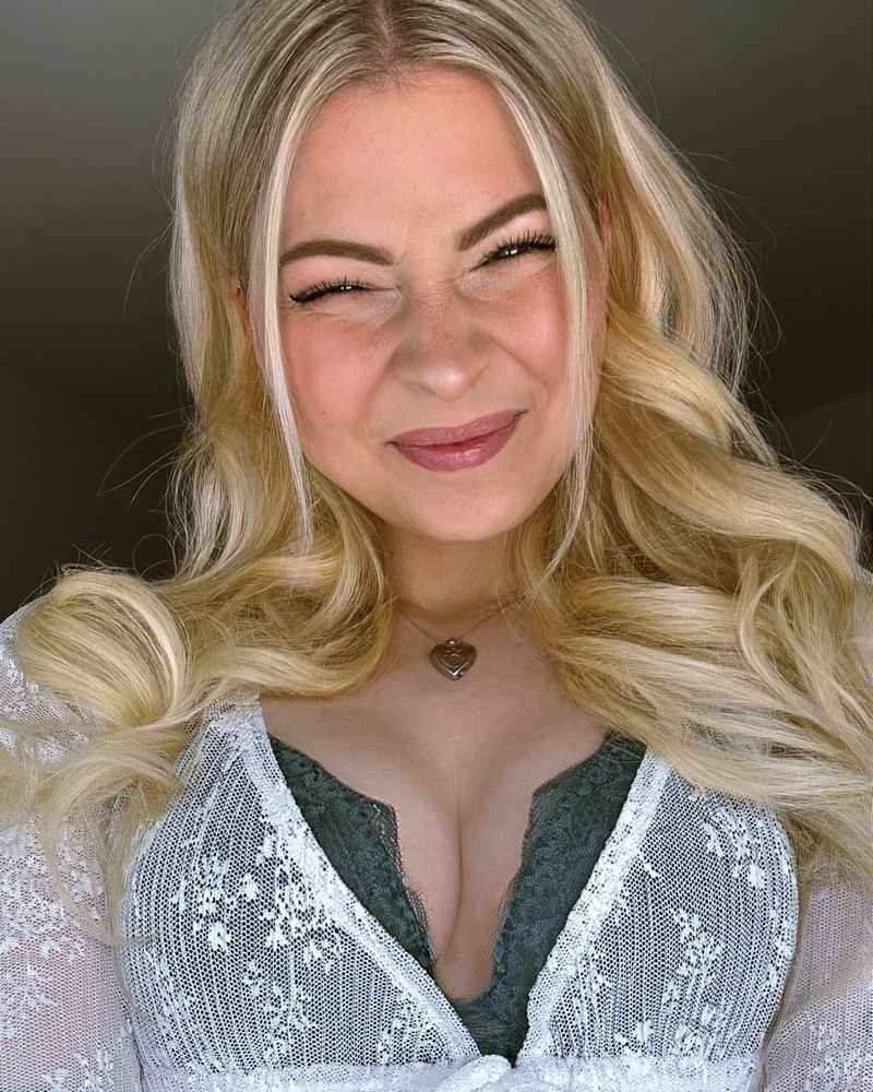 Janina Wilhelmsen schaut süß in die Kamera und drückt die Brüste hoch