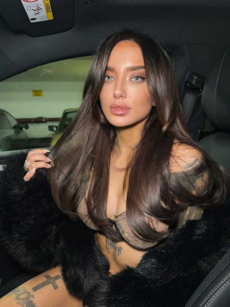 Cherry Rebelle sitzt im Auto nur mit Dessous bekleidet