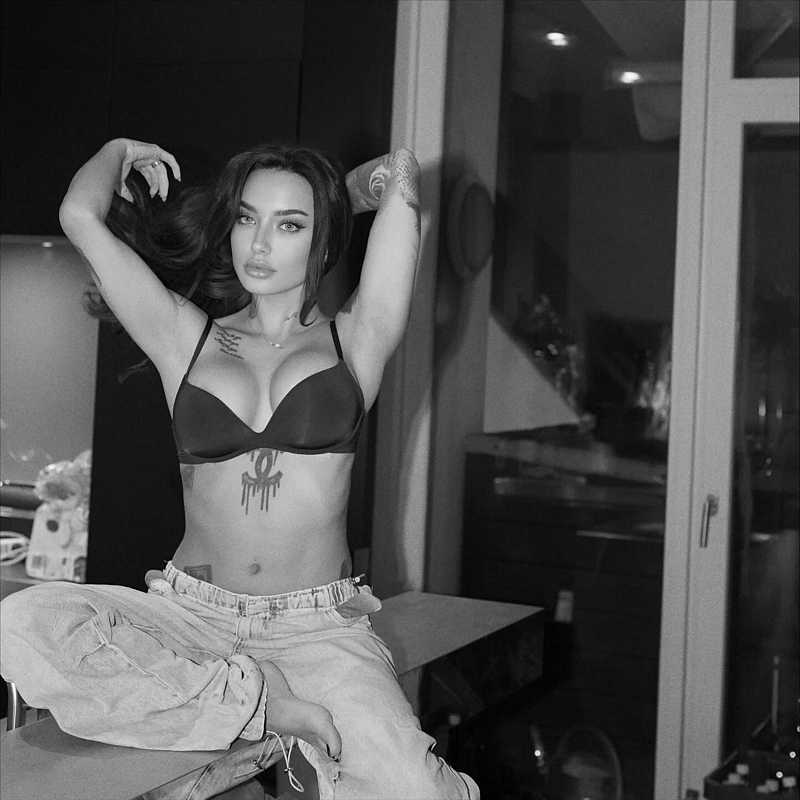 Cherry Rebelle trägt nur einen BH am Oberkörper