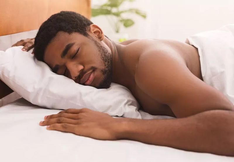 Person in bed sleeping naked
