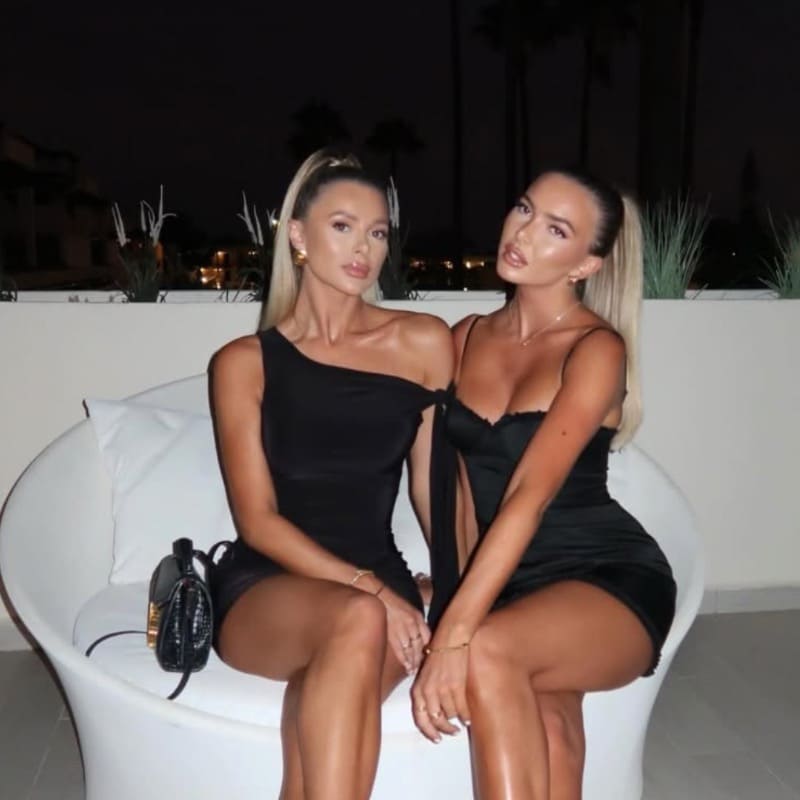 Sexy blondes in short dresses on white couch