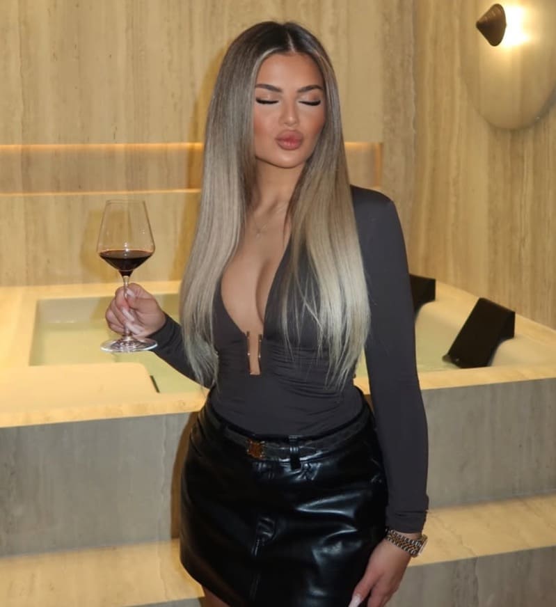 Blonde babe with big tits drinking wine