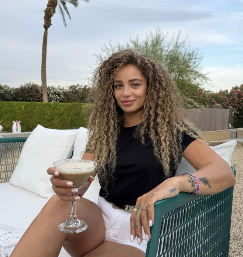 Tori holding a drink in bar