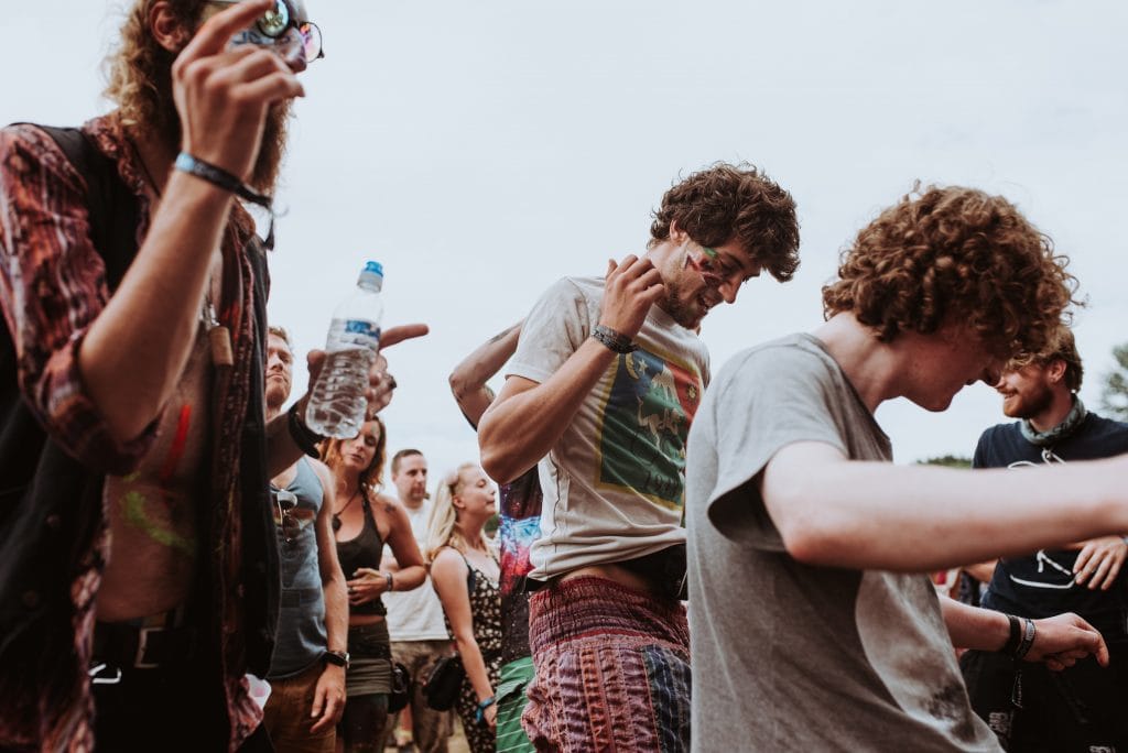 drie dansende festivalgangers in hipsterblousjes
