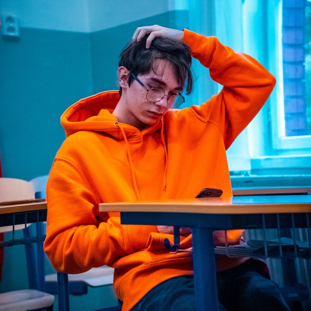 Leyo op zijn telefoon in de klas