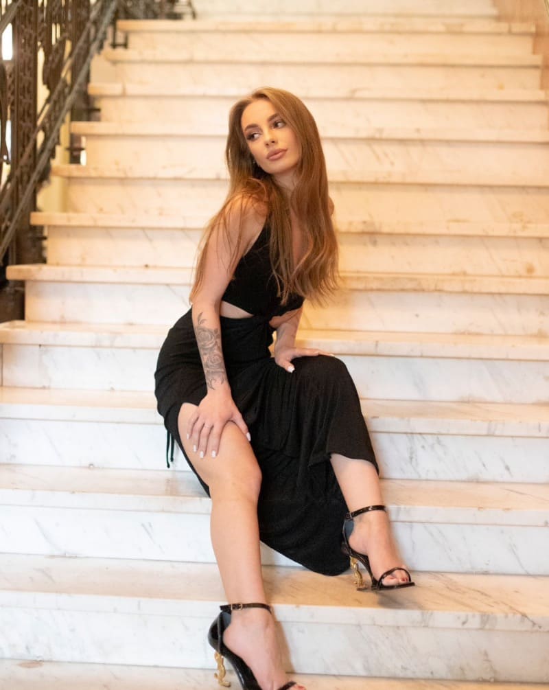 Babe in zwarte jurk op trappen