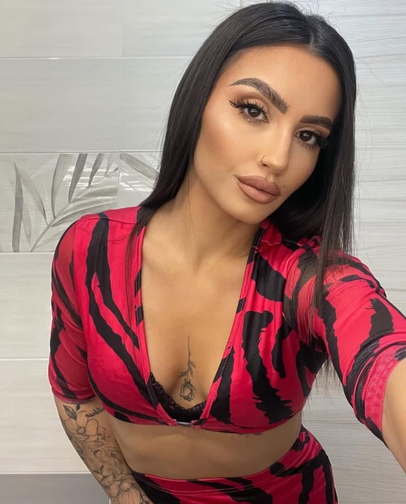 Ilaria in rode outfit met diepe decolleté