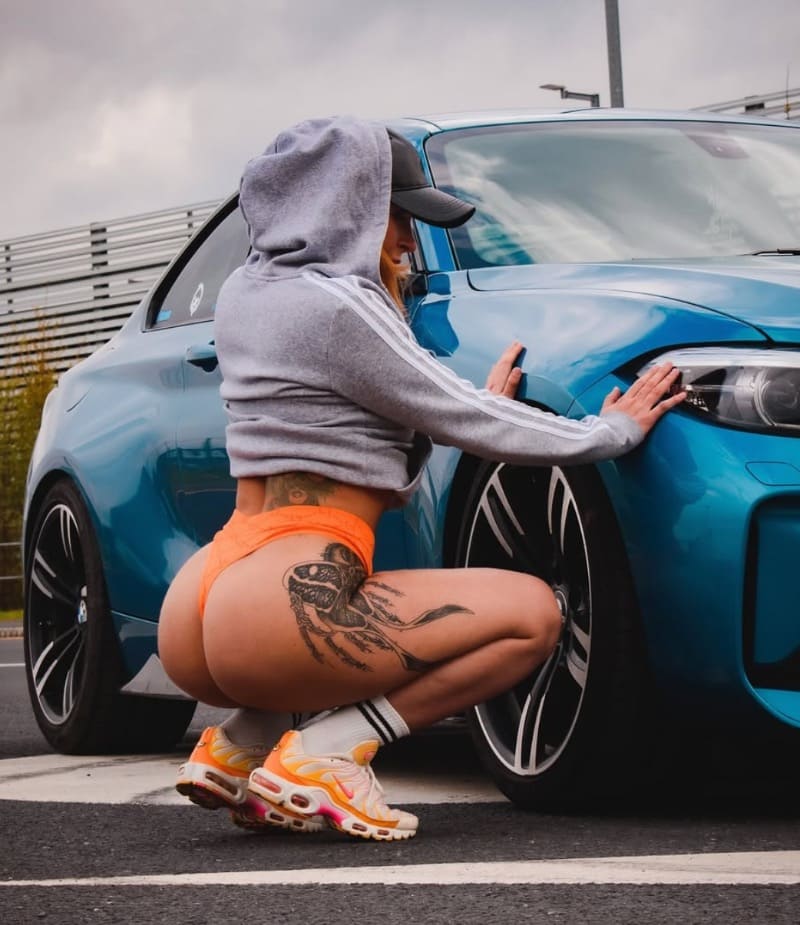 Becky met bolle billen naast auto