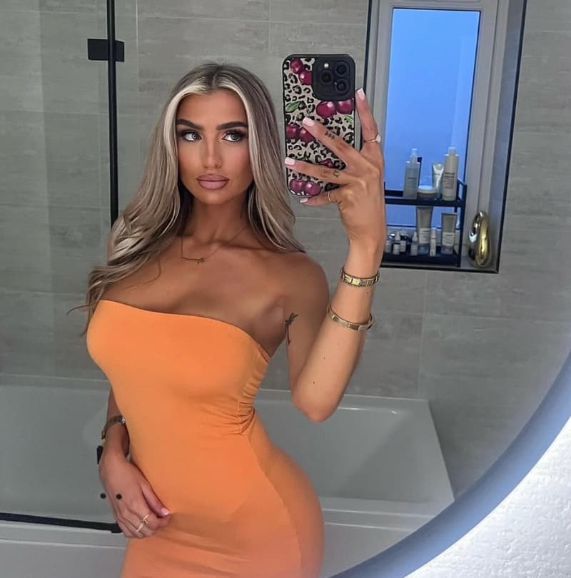 Sexy blondine in strakke oranje jurk