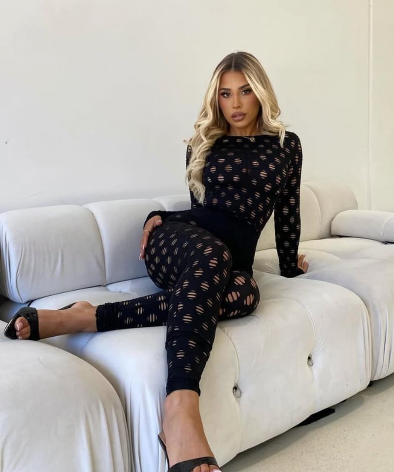Babe in sexy outfitje op zetel