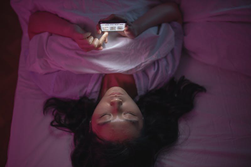Vrouw in bed voor langeafstandrelatie