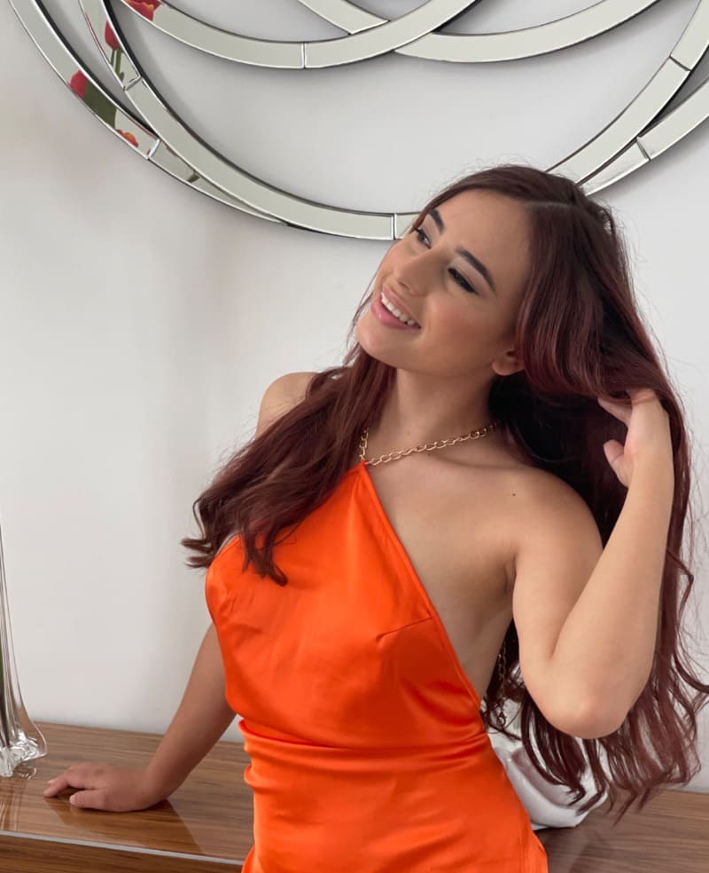 Knappe dame in oranje met sexy jurk