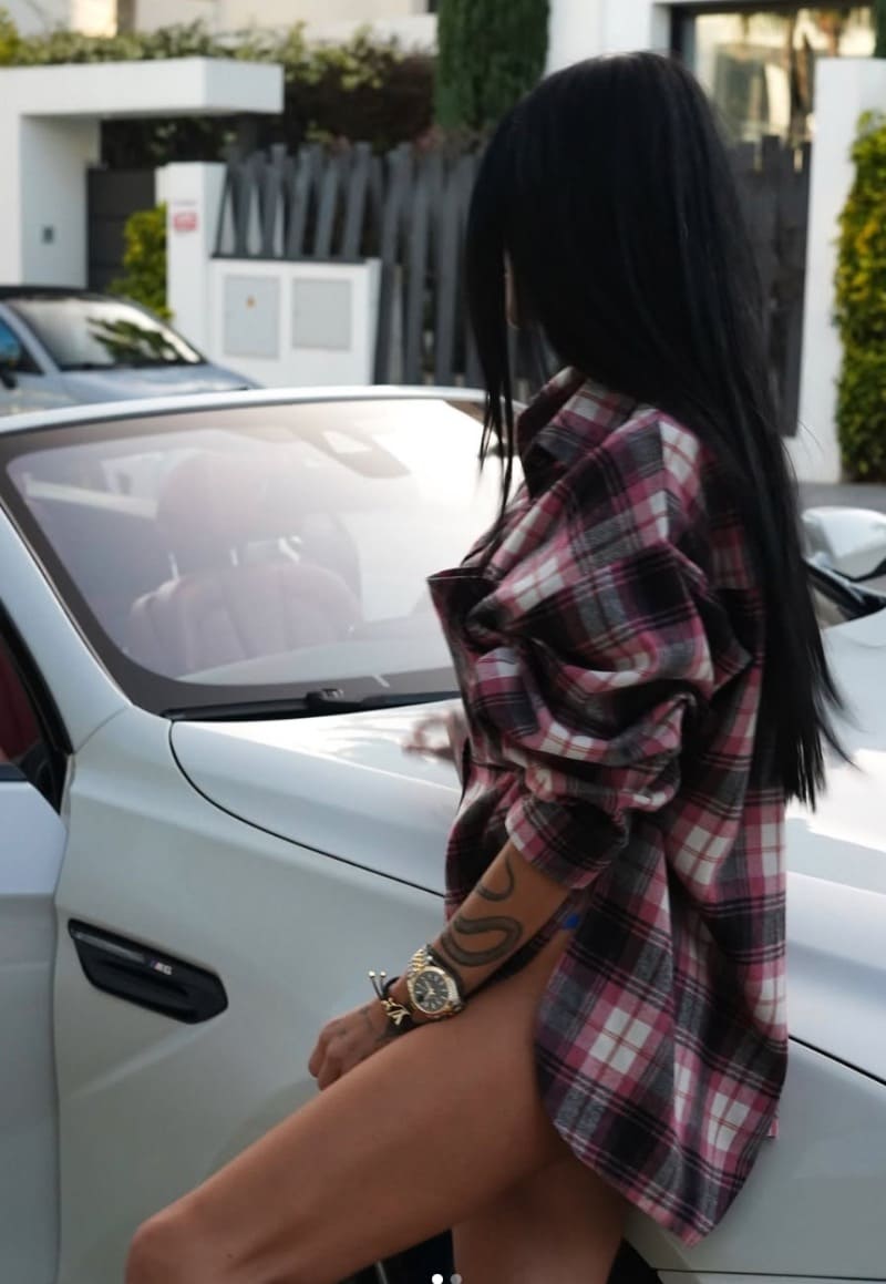 Voronova met billen tegen auto