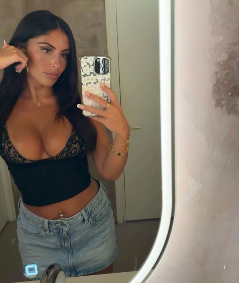 Holly in strak zwart topje en jeans