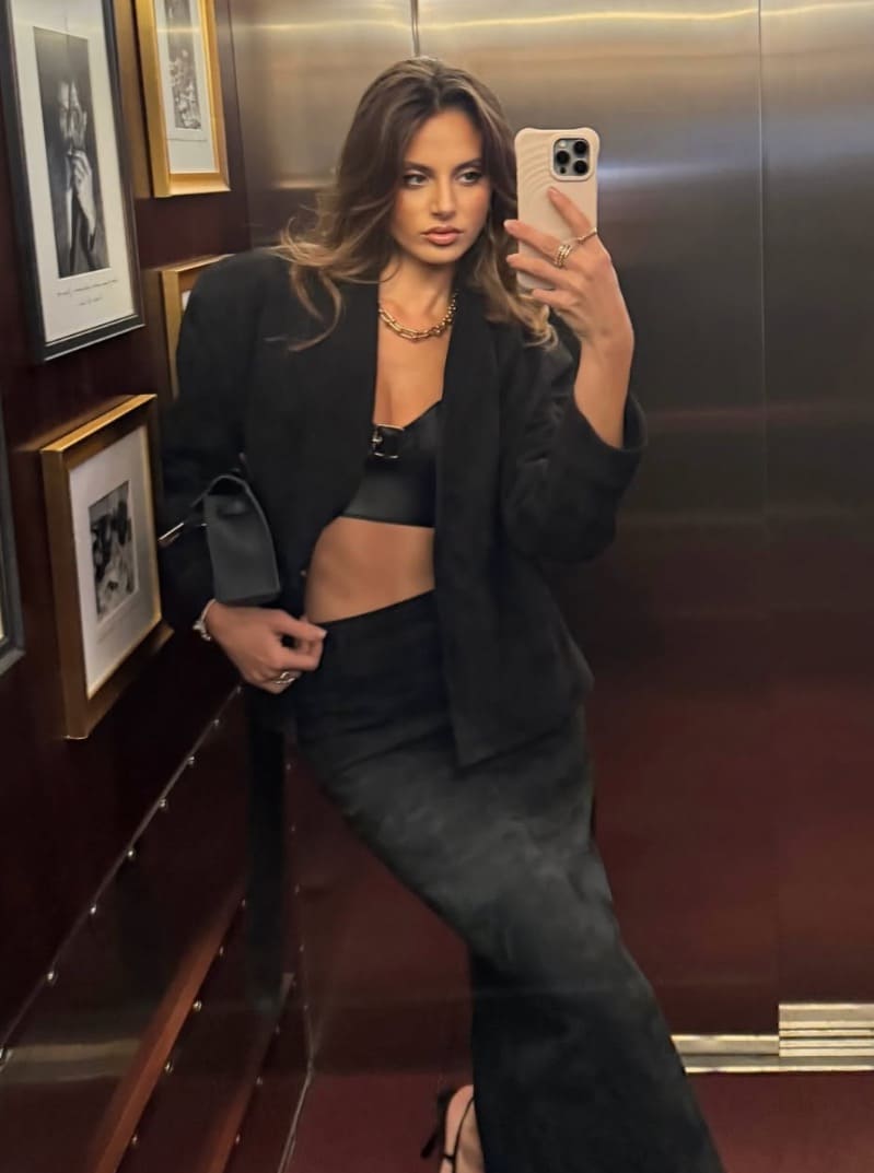 Carina in zwarte outfit met lingerie onder