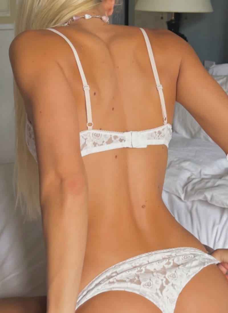 Blondine met lange haren in witte lingerie