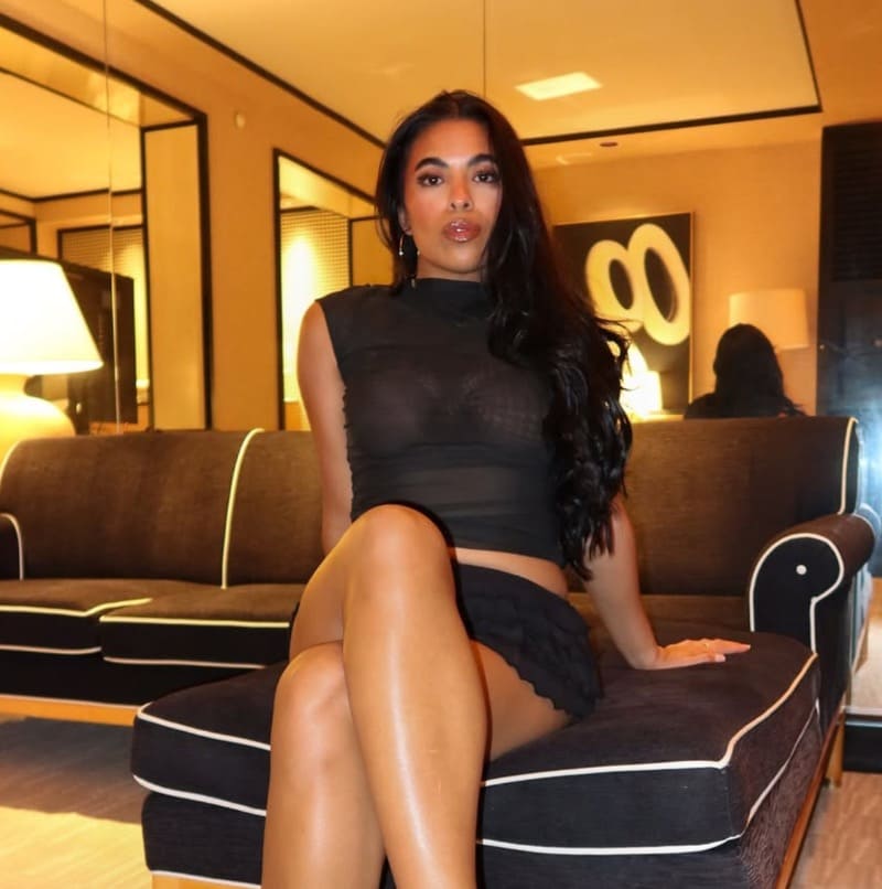 Babe in sexy zwarte outfit op zetel