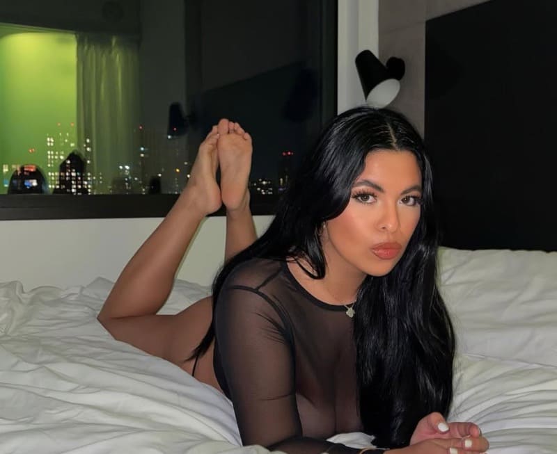 Rakita op bed in zwarte sexy outfit