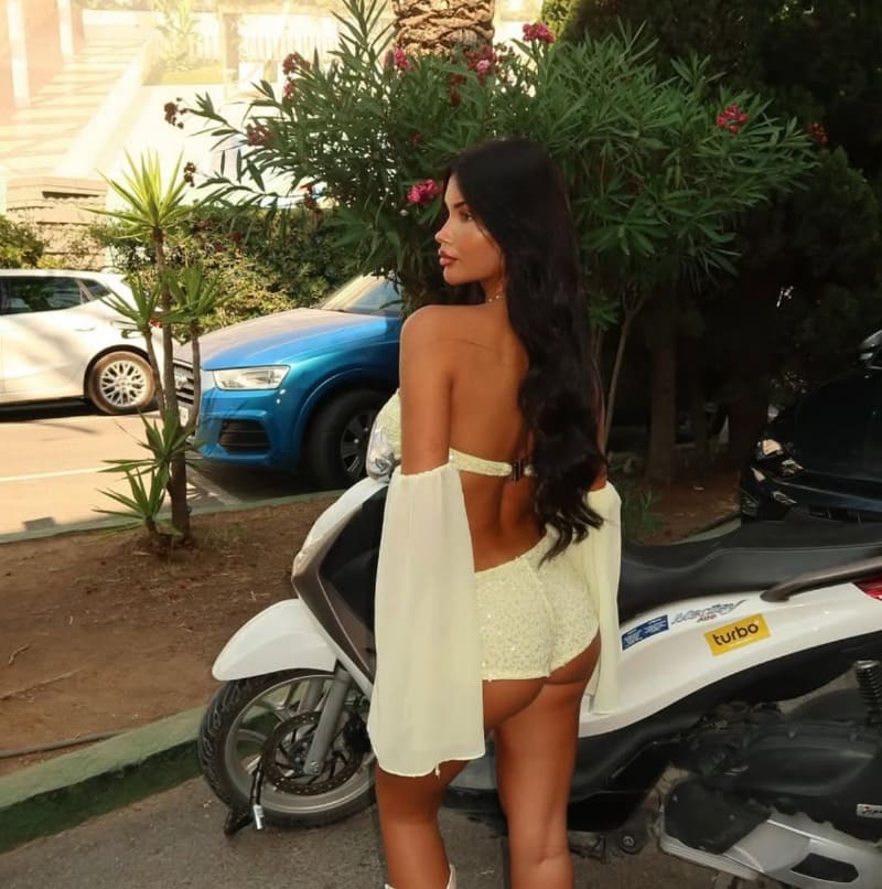 Sexy brunette naast vespa