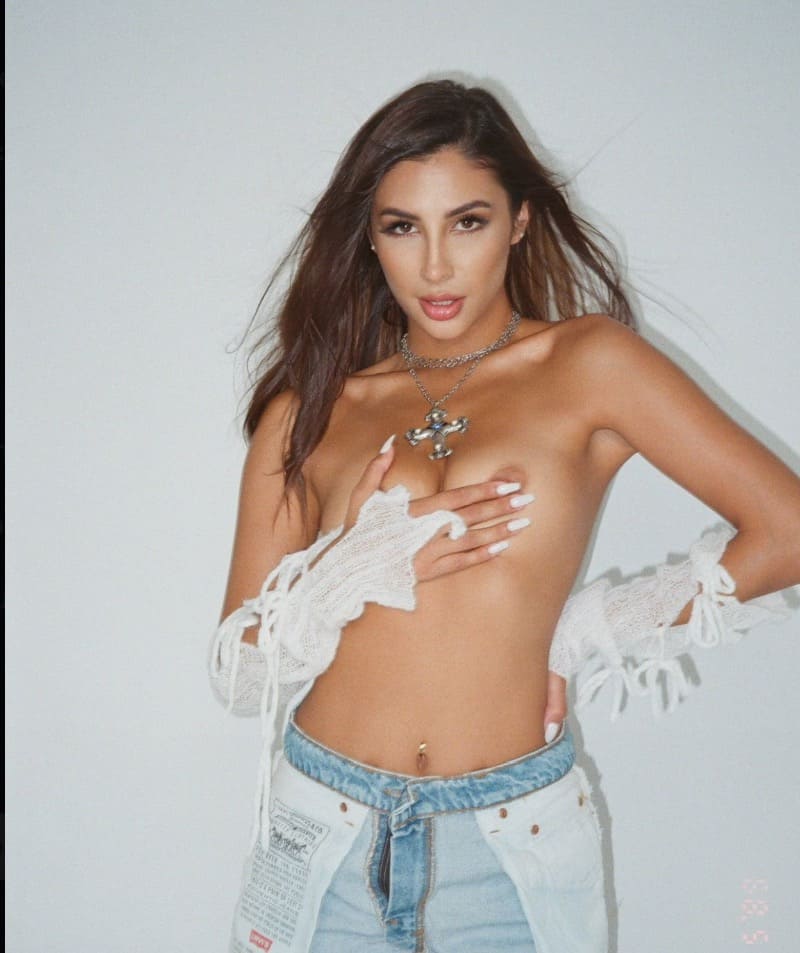 Babe half naakt voor witte muur 