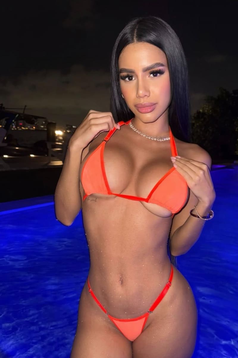 Andreina in oranje bikini in water