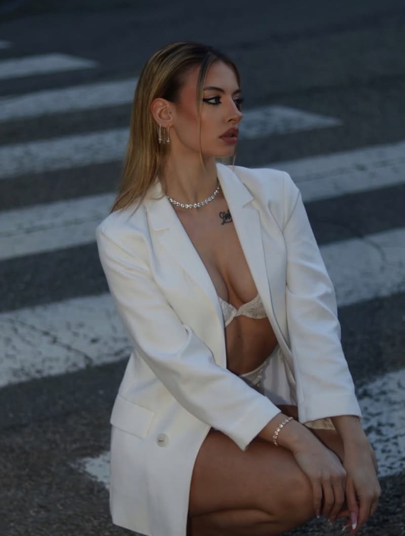 Rosaria in witte lingerie onder jasje